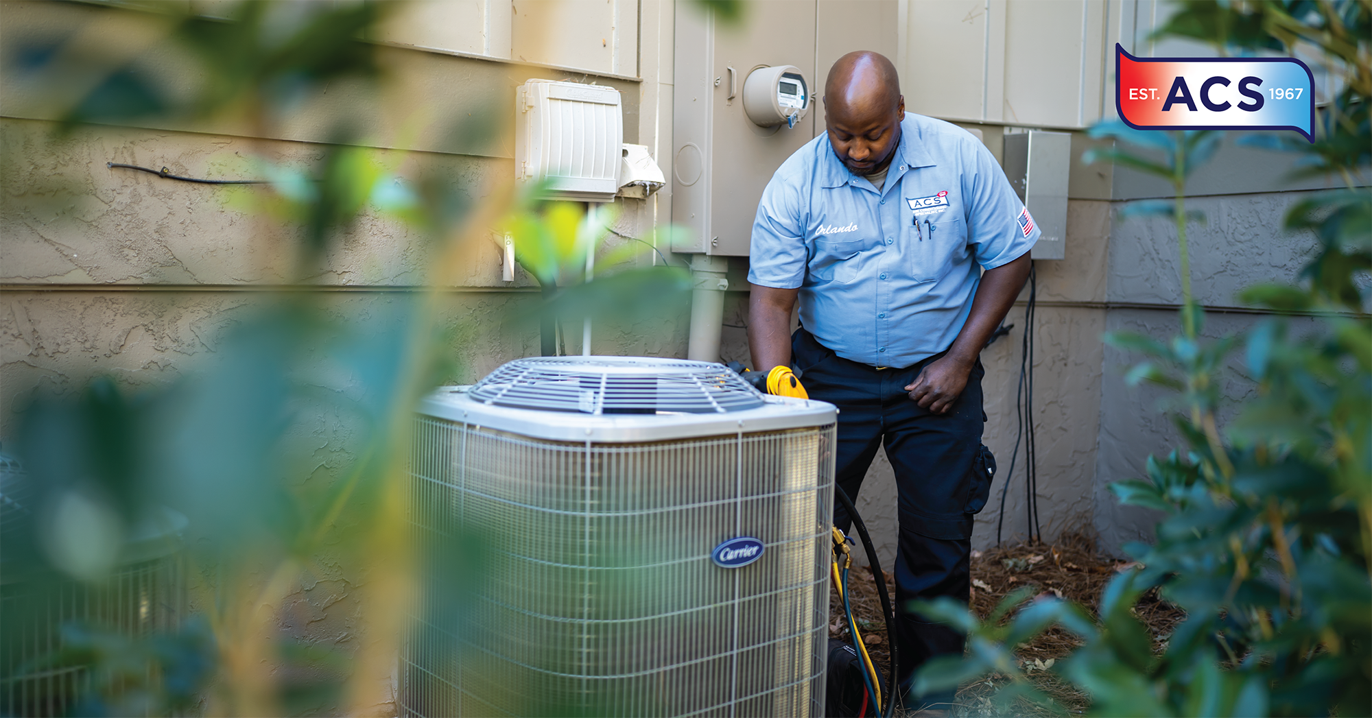 African American HVAC repair man looking at an outside HVAC unit