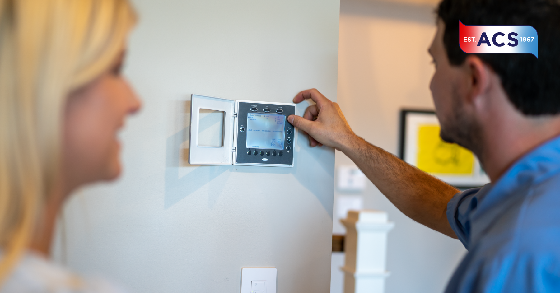 HVAC Technician adjusting a thermostat for a homeowner