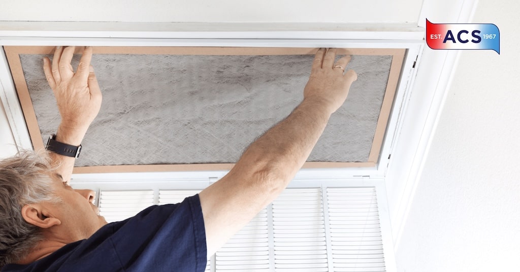 ACS HVAC Technician replacing air filter for AC Unit