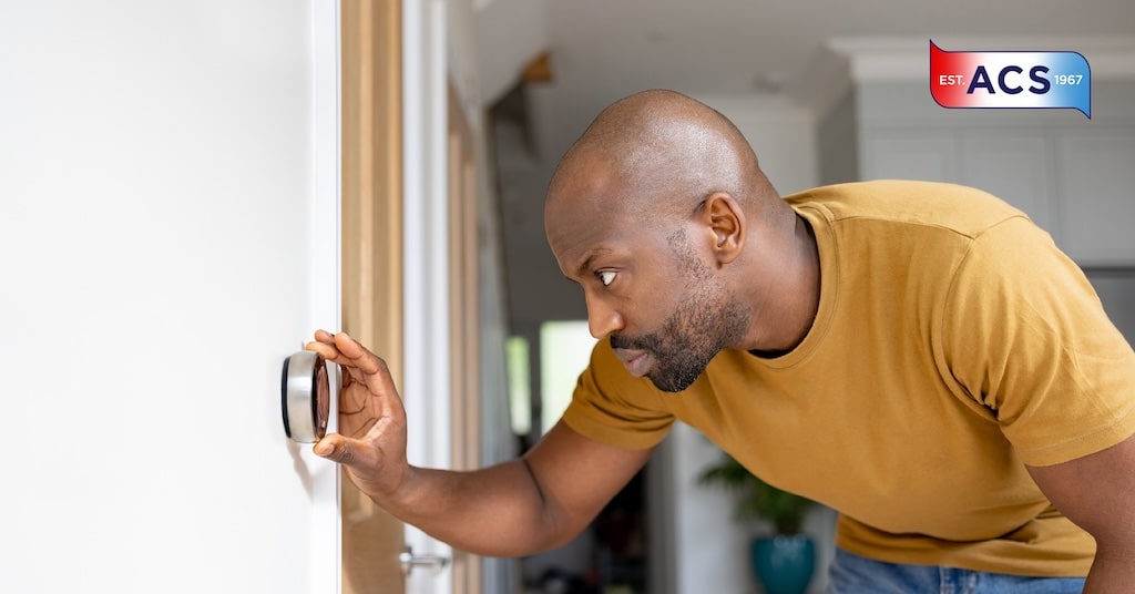 Man adjusting the smart thermostat in the home