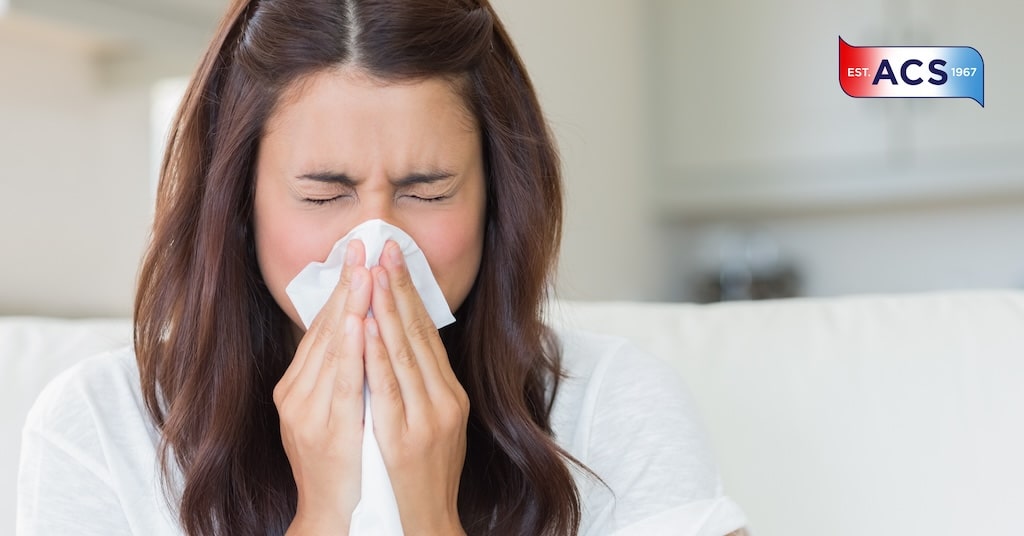 Brunette woman sneezing as she needs an air purification system