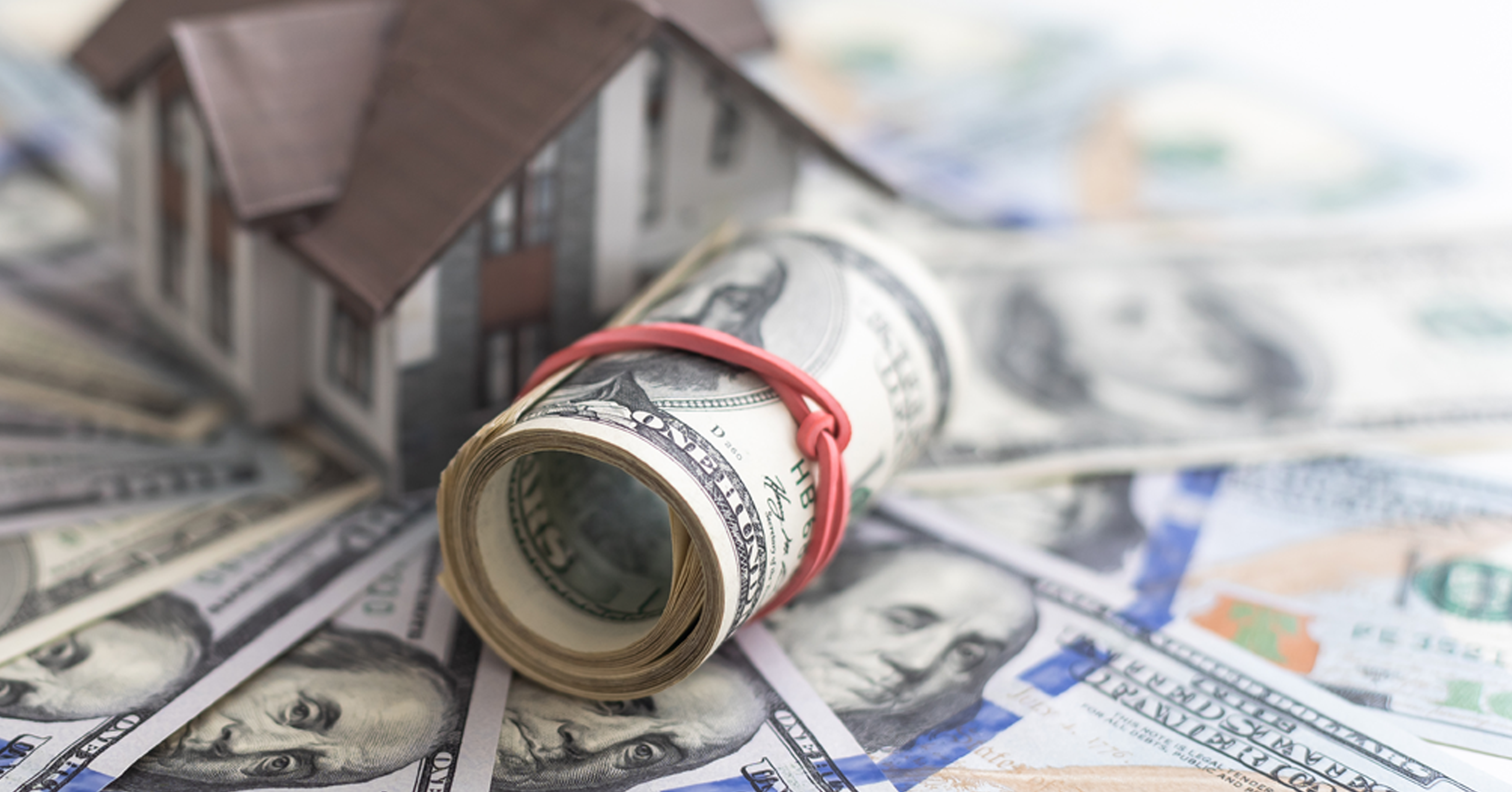 The symbol of the house stands against the background of us dollars stock photo