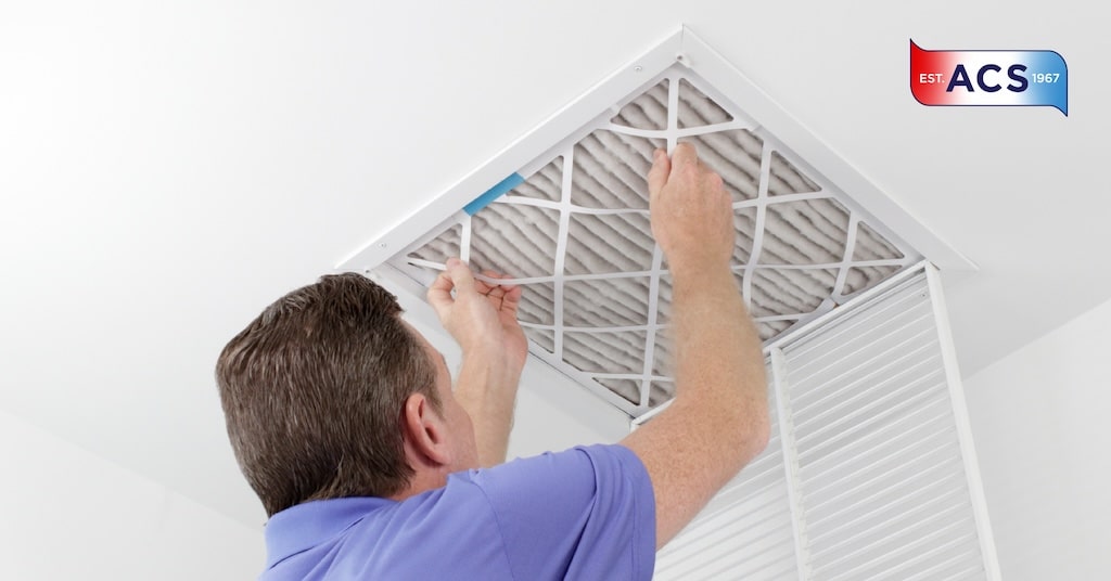 Homeowner changing his home's air filter