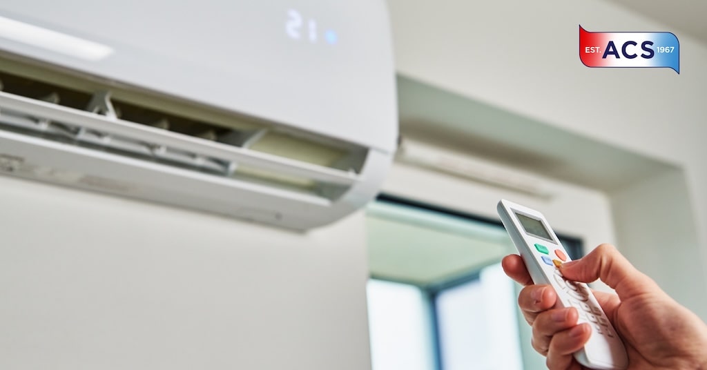 Person trying to turn on broken air conditioner with remote