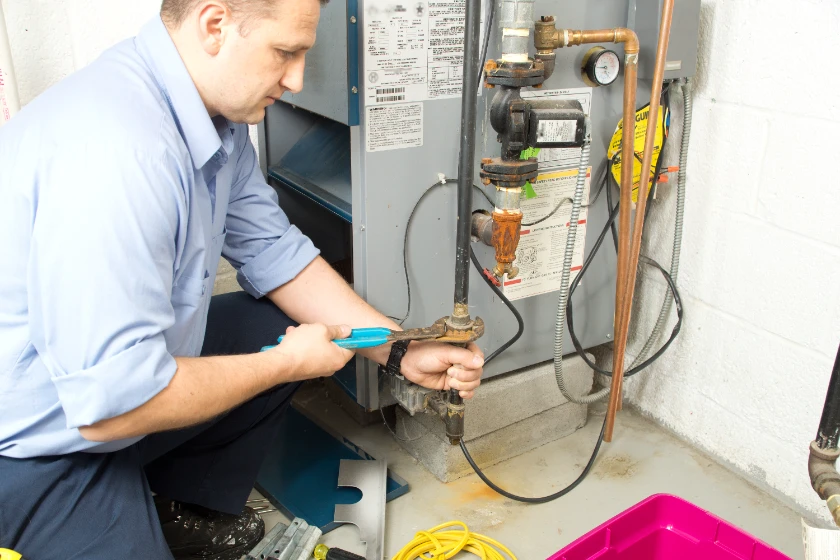 A technician repairing a furnace
