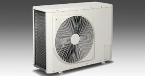 A white outdoor air conditioning unit with a visible fan and grille, placed on a gray surface against a gradient commercial refrigeration maintenance