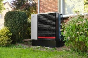 %Imagetitle% | Air Conditioning Specialists Alpha Innotec heat pump installed outside a brick house. Heat Pump vs Furnace