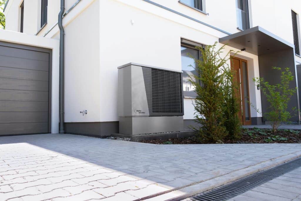 An Alpha Innotec heat pump installed outside a white house. Furnace Safety Inspection